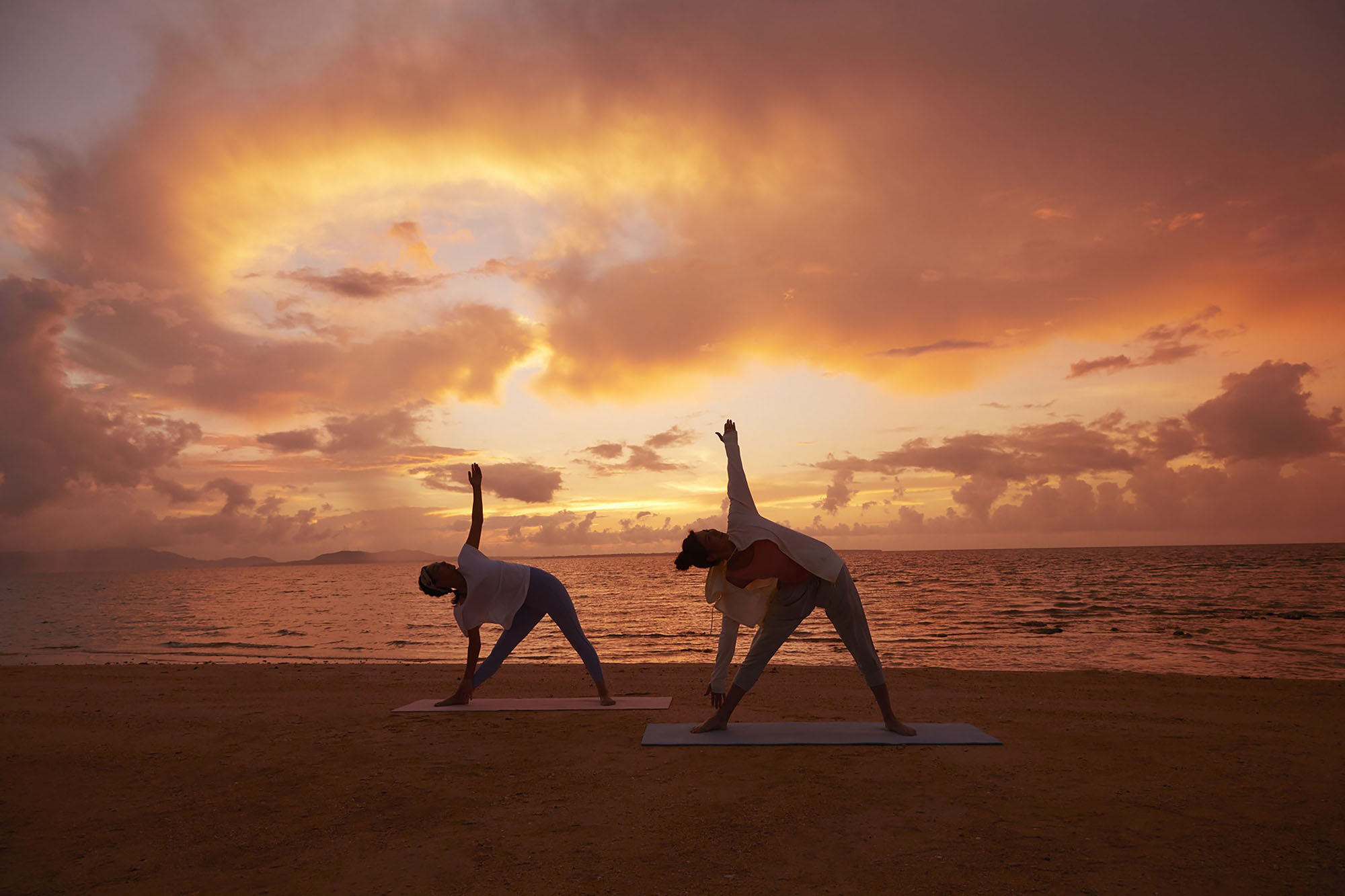 珊瑚の海と朝日を望む「モーニングビーチヨガ」 【公式】星野リゾート リゾナーレ小浜島｜星野リゾート 珊瑚礁と白砂のビーチに抱かれた